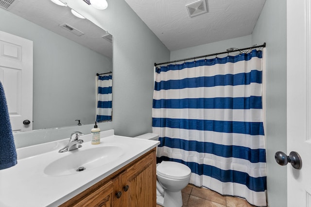 bathroom featuring toilet, vanity, tile patterned floors, and curtained shower