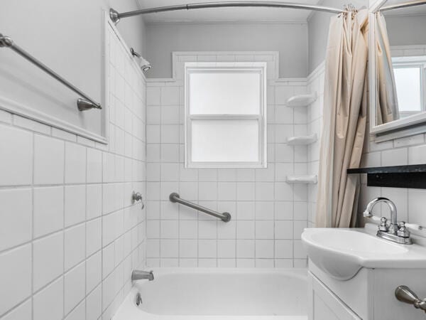 603 E Maupin St, Bolivar, MO 65613 - full bathroom featuring shower / tub combo with curtain, vanity, and tile walls