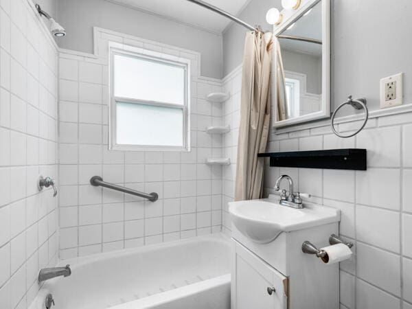 603 E Maupin St, Bolivar, MO 65613 - bathroom featuring shower / bath combination with curtain, tile walls, and vanity
