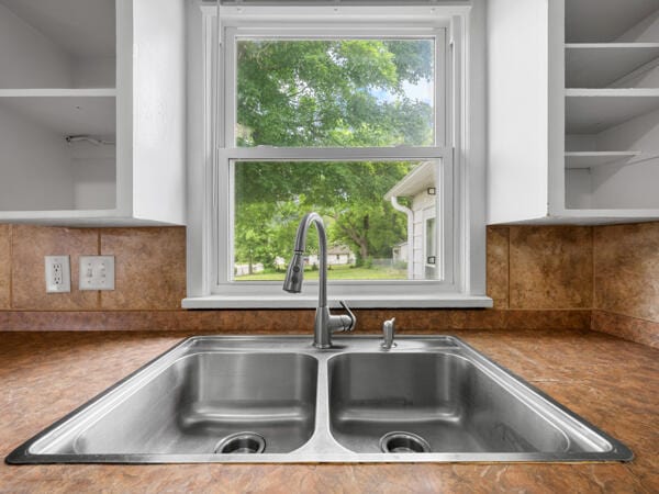 603 E Maupin St, Bolivar, MO 65613 - kitchen view of a sink, white cabinetry, glass insert cabinets, and backsplash