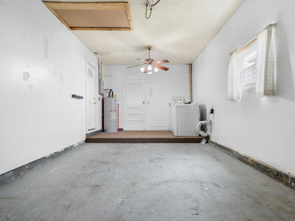 603 E Maupin St, Bolivar, MO 65613 - garage featuring water heater, washer / dryer, and ceiling fan
