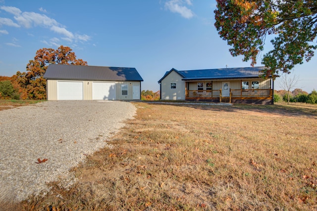 view of front of house featuring an outbuilding, a garage, a front lawn, and a porch