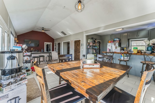 dining area with vaulted ceiling, light tile patterned floors, and ceiling fan