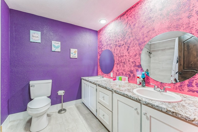 bathroom with toilet, vanity, and tile patterned flooring