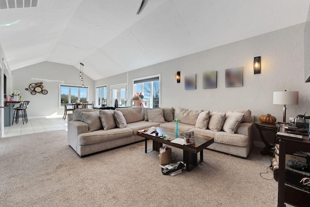 carpeted living room with a wealth of natural light and lofted ceiling