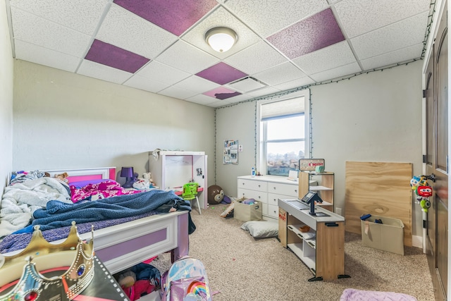 carpeted bedroom featuring a drop ceiling