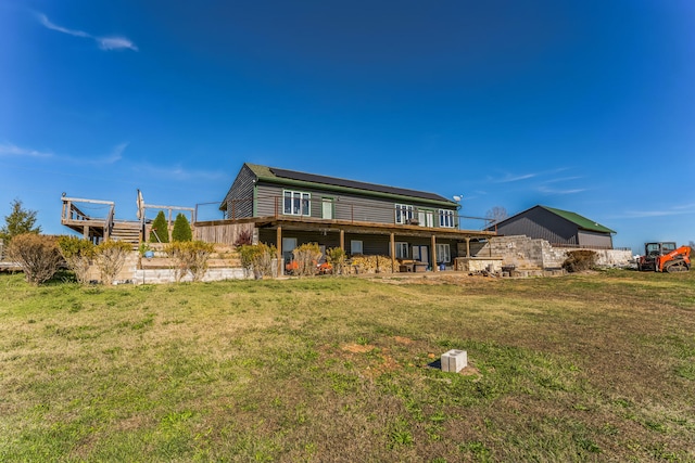 rear view of house featuring a wooden deck and a yard