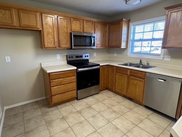 kitchen featuring stainless steel appliances, sink, and light tile patterned floors