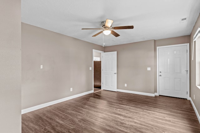 spare room with dark hardwood / wood-style flooring and ceiling fan