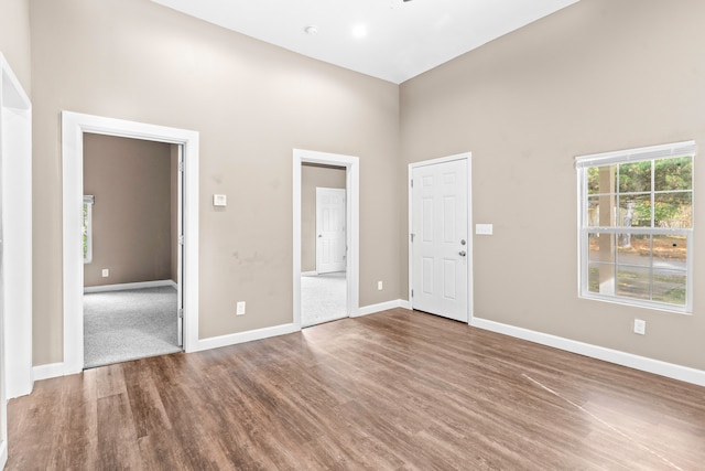 spare room with hardwood / wood-style floors and a high ceiling