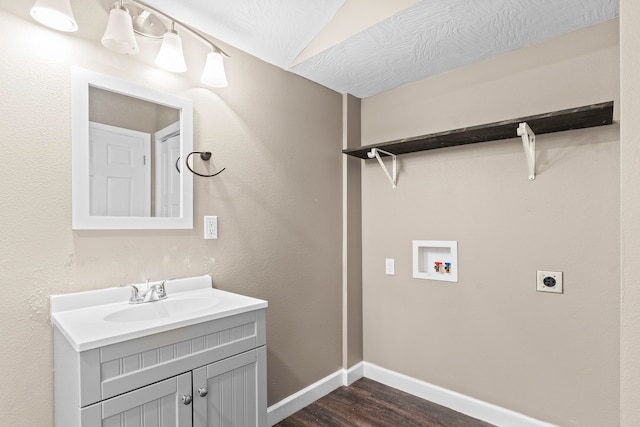 clothes washing area featuring hookup for a washing machine, electric dryer hookup, sink, and dark wood-type flooring