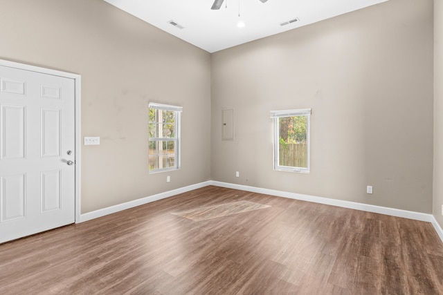 empty room featuring hardwood / wood-style flooring, a healthy amount of sunlight, and ceiling fan