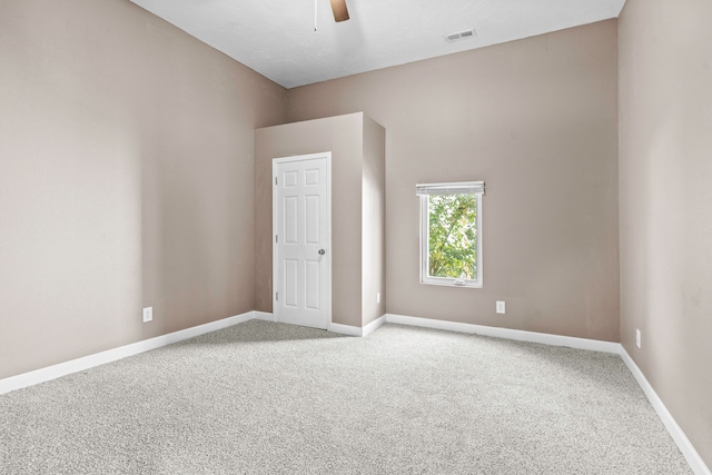 carpeted spare room with ceiling fan