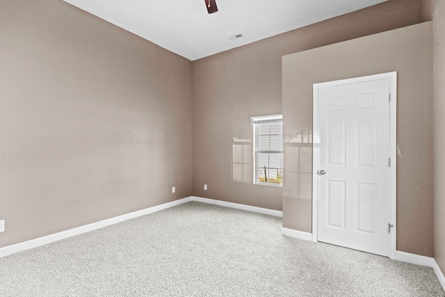 empty room featuring ceiling fan and light colored carpet