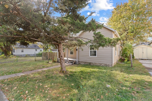 view of property hidden behind natural elements featuring a storage unit and a front yard