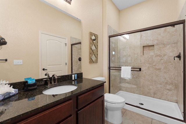 bathroom with walk in shower, vanity, toilet, and tile patterned floors