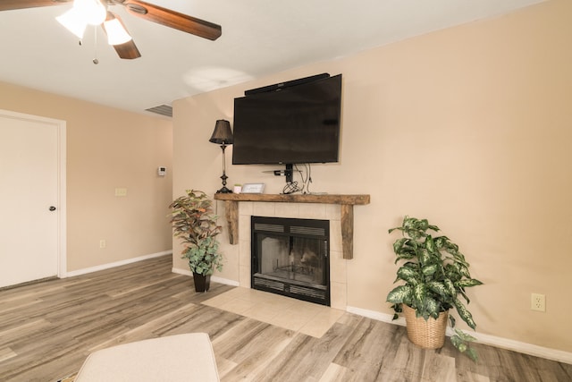 living room with hardwood / wood-style floors, a fireplace, and ceiling fan