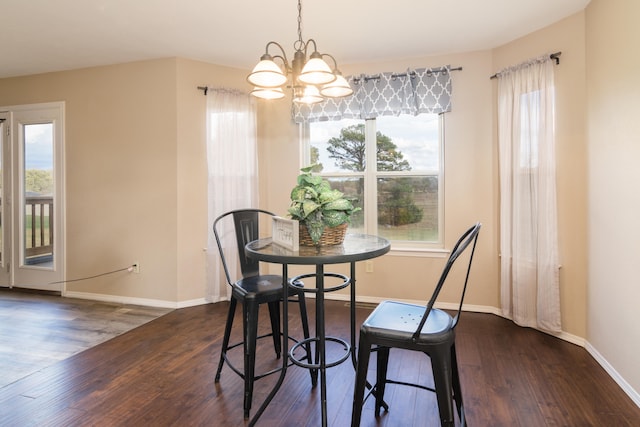 dining space featuring dark wood-type flooring and a notable chandelier