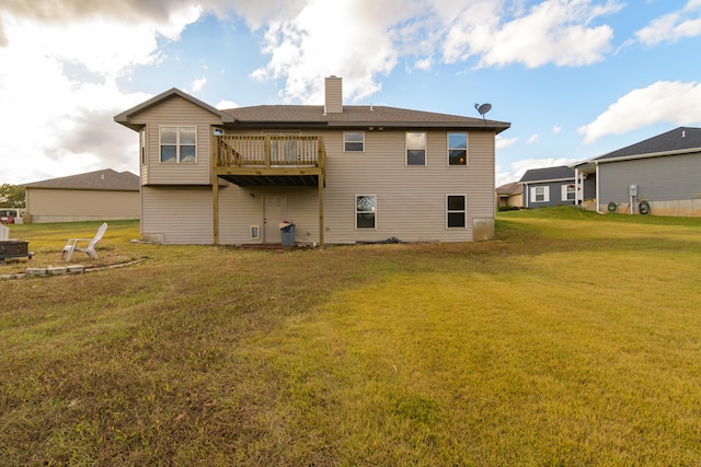 back of property with a yard and a wooden deck