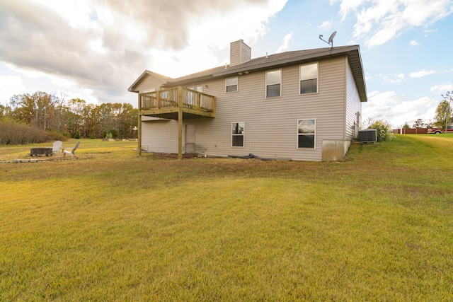 rear view of property featuring a lawn and central AC