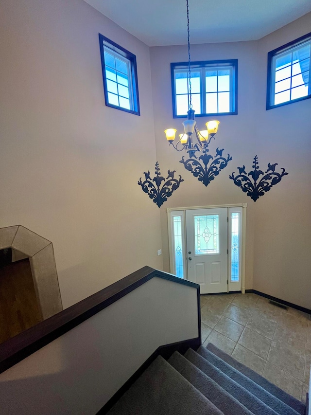 foyer featuring a chandelier, a wealth of natural light, and light tile patterned flooring