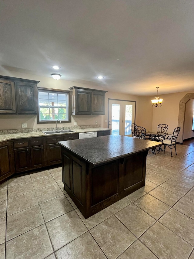 kitchen featuring a notable chandelier, dark brown cabinets, a center island, and sink