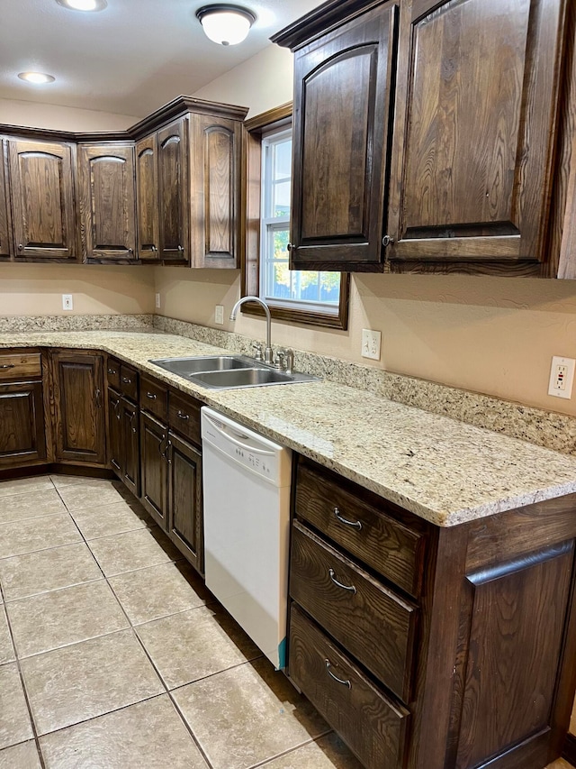 kitchen with light stone countertops, sink, white dishwasher, dark brown cabinets, and light tile patterned floors