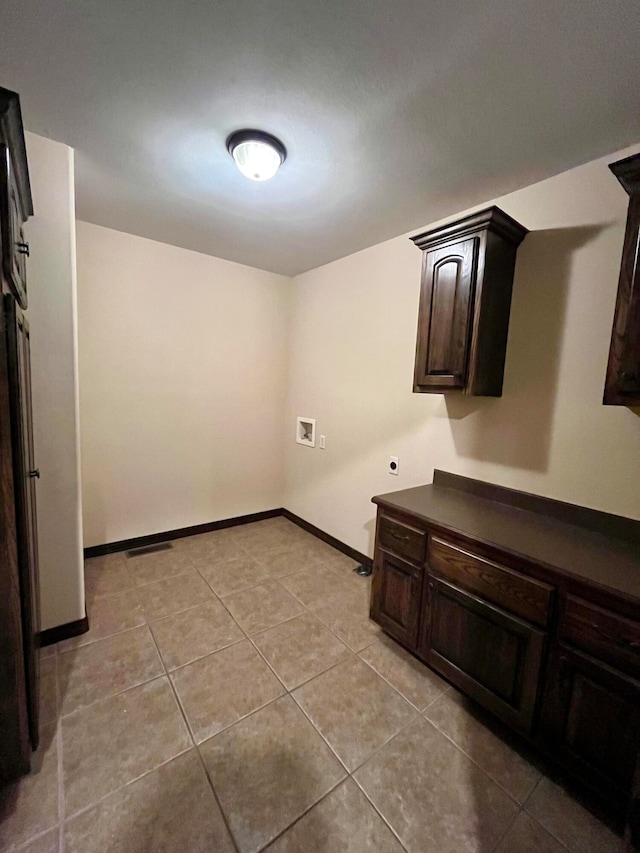 clothes washing area with washer hookup, electric dryer hookup, cabinets, and light tile patterned floors