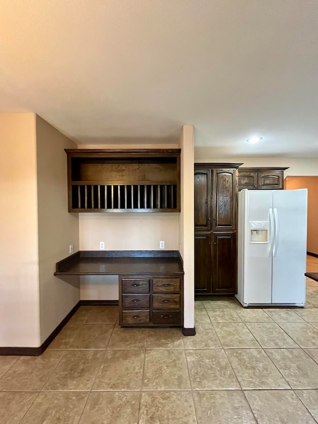 kitchen featuring light tile patterned flooring, dark brown cabinetry, and white fridge with ice dispenser