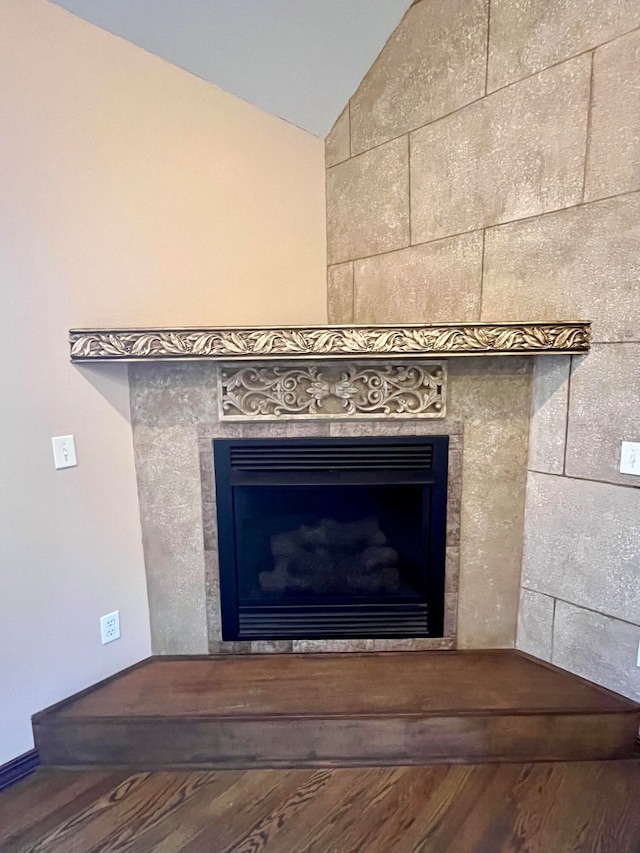 interior details featuring hardwood / wood-style flooring and a tile fireplace