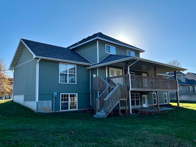 rear view of house with a patio area, a yard, and a wooden deck