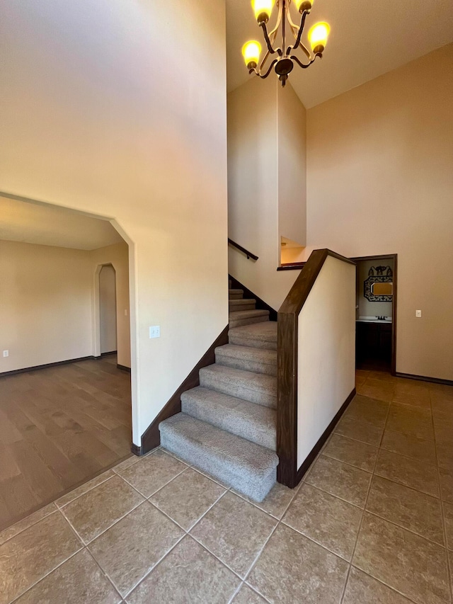 stairs featuring tile patterned flooring and a notable chandelier