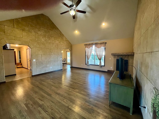 unfurnished living room featuring ceiling fan, wood-type flooring, and high vaulted ceiling