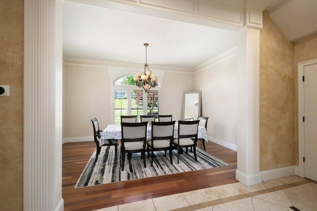 dining space featuring a notable chandelier, light hardwood / wood-style flooring, crown molding, and decorative columns