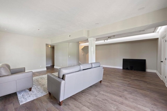 living room with decorative columns and hardwood / wood-style floors