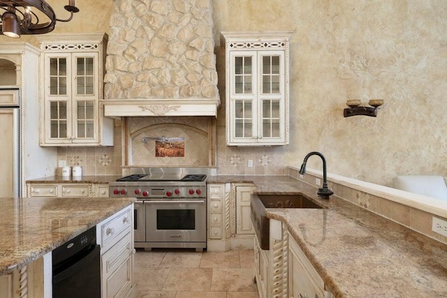 kitchen with light stone countertops, cream cabinets, and range with two ovens