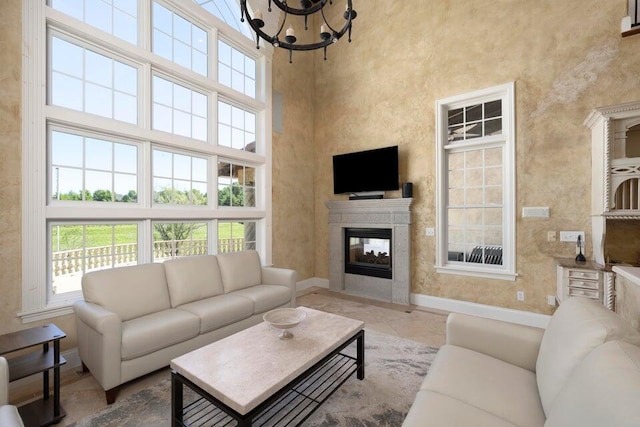 living room featuring a high ceiling, a chandelier, and tile patterned flooring