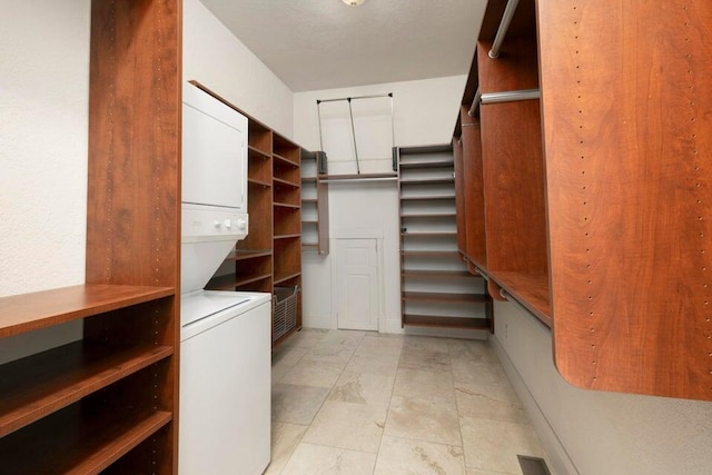 walk in closet with stacked washer and clothes dryer