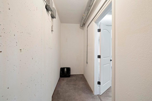 hall featuring a textured ceiling and carpet floors