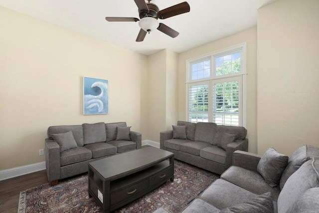 living room with dark wood-type flooring and ceiling fan