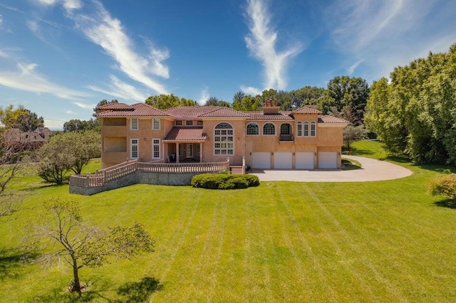 back of house featuring a garage and a lawn