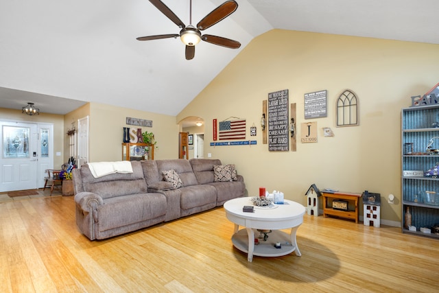 living room with high vaulted ceiling, hardwood / wood-style flooring, and ceiling fan with notable chandelier