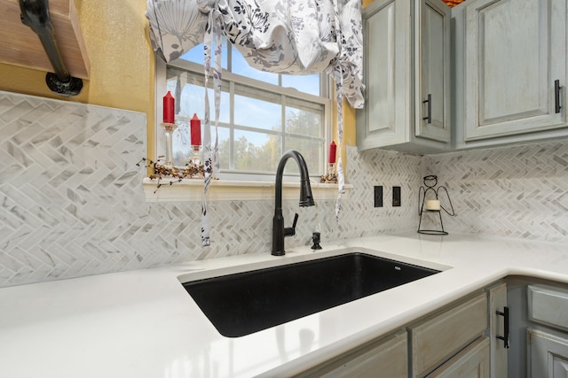 kitchen with gray cabinets, sink, and decorative backsplash