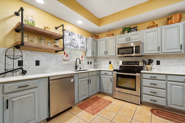 kitchen featuring tasteful backsplash, sink, light tile patterned flooring, and stainless steel appliances