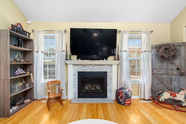 living room with a fireplace, wood-type flooring, and a textured ceiling