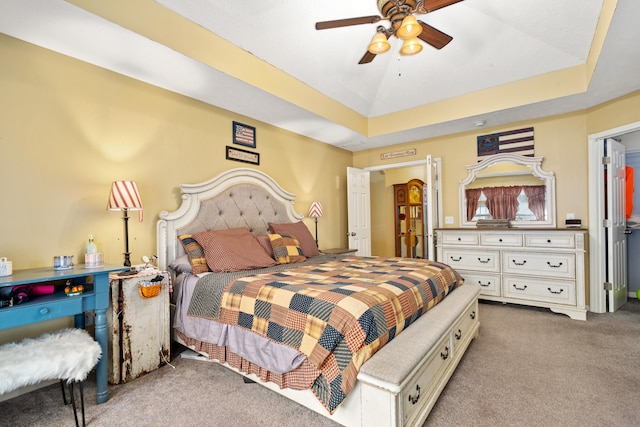 bedroom featuring ceiling fan, carpet floors, and a tray ceiling