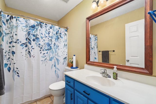 bathroom with toilet, vanity, a textured ceiling, and tile patterned floors