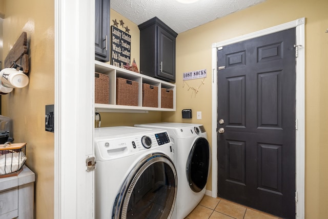 laundry room featuring cabinets, separate washer and dryer, a textured ceiling, and light tile patterned floors