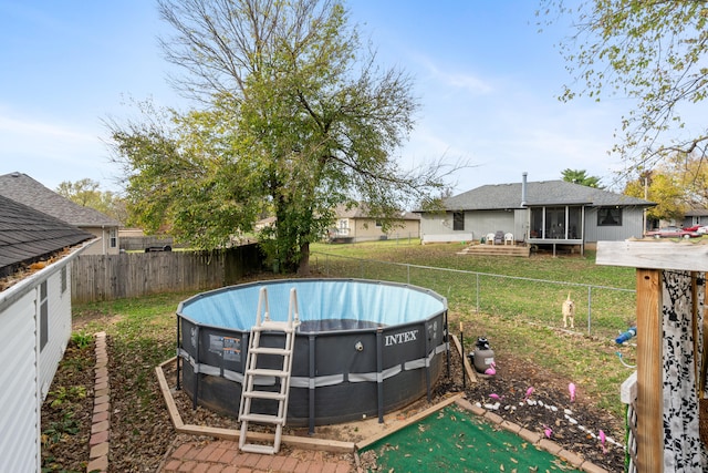 view of yard with a fenced in pool and a sunroom