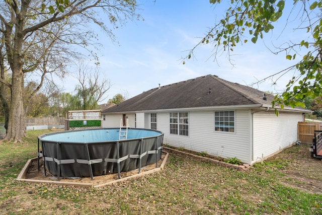 rear view of property featuring a fenced in pool